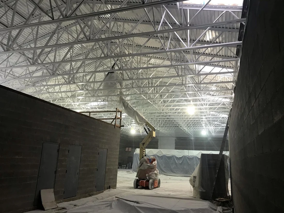 Commercial painting with access equipment and protected areas.